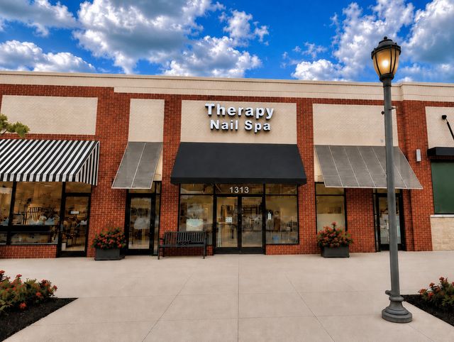 The Therapy Nail Spa storefront — brick building with a black awning and the Therapy Nail Spa sign above the entrance